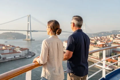 Couple sur le pont d'un bateau de croisière au départ de Lisbonne avec vue sur le pont du 25 Avril