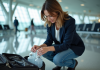 Restriction bagages enregistrés : liquides autorisés ? Conseils pratiques Femme organisant des liquides de voyage dans un aéroport