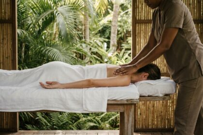 Massage relaxant en plein air dans un spa tropical en Guadeloupe, femme allongée sur une table en bois entourée de végétation luxuriante