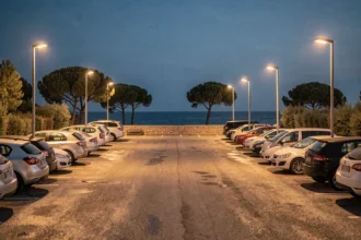 Parking organisé près du port de Porquerolles la nuit avec des voitures garées en rangées sous des lampadaires ambrés