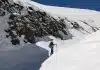 a person walking up the side of a snow covered mountain